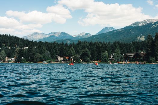 Lakeside view with kayaks and mountains in Whistler, BC during summer.