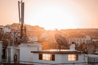 城市景观中，日出照亮了屋顶和卫星天线