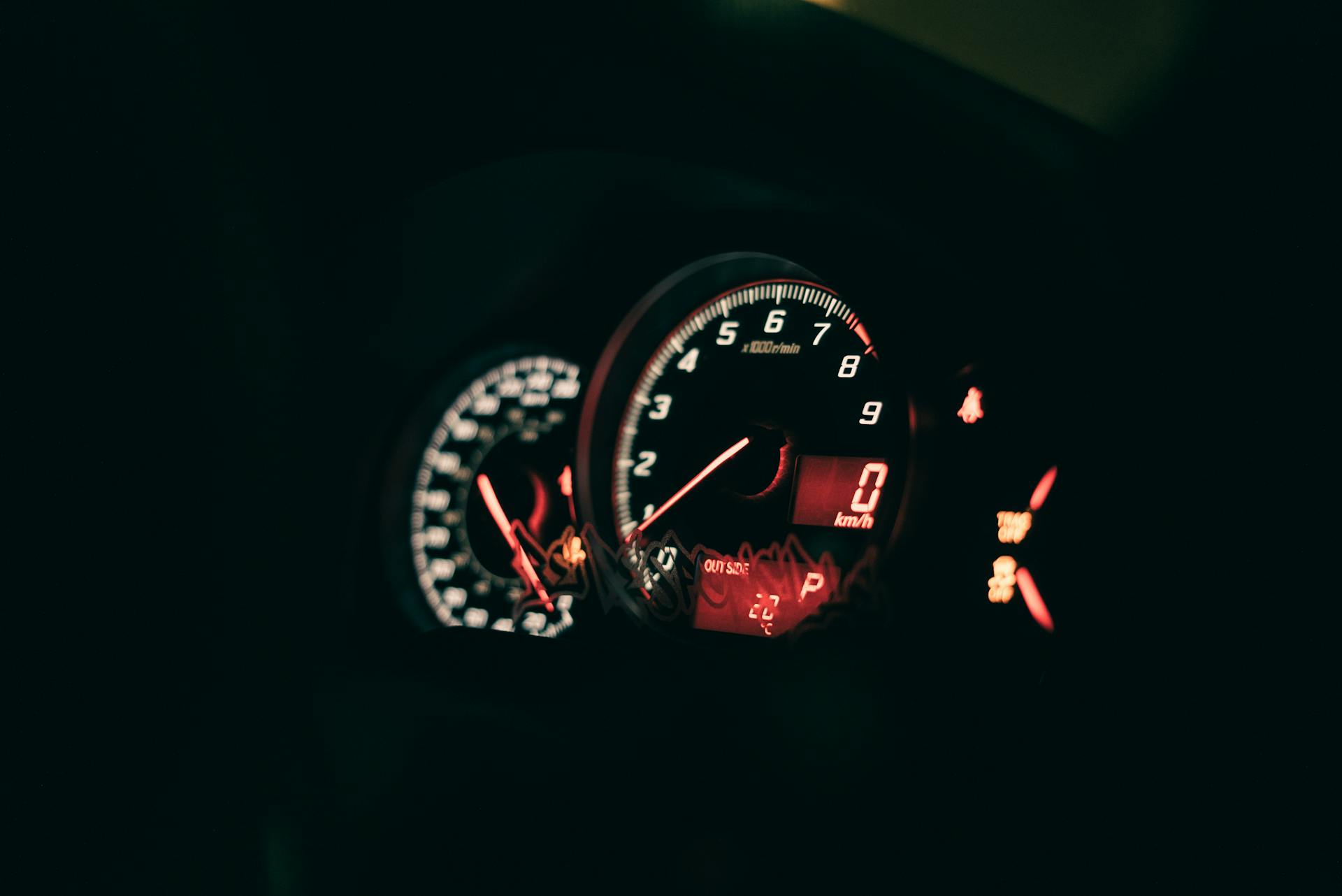 Close-up shot of a car's illuminated speedometer and dashboard controls, conveying speed and precision.