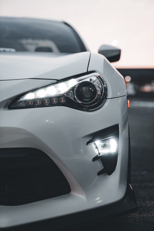 Free Sleek white car featuring modern LED headlights and detailed front design. Stock Photo