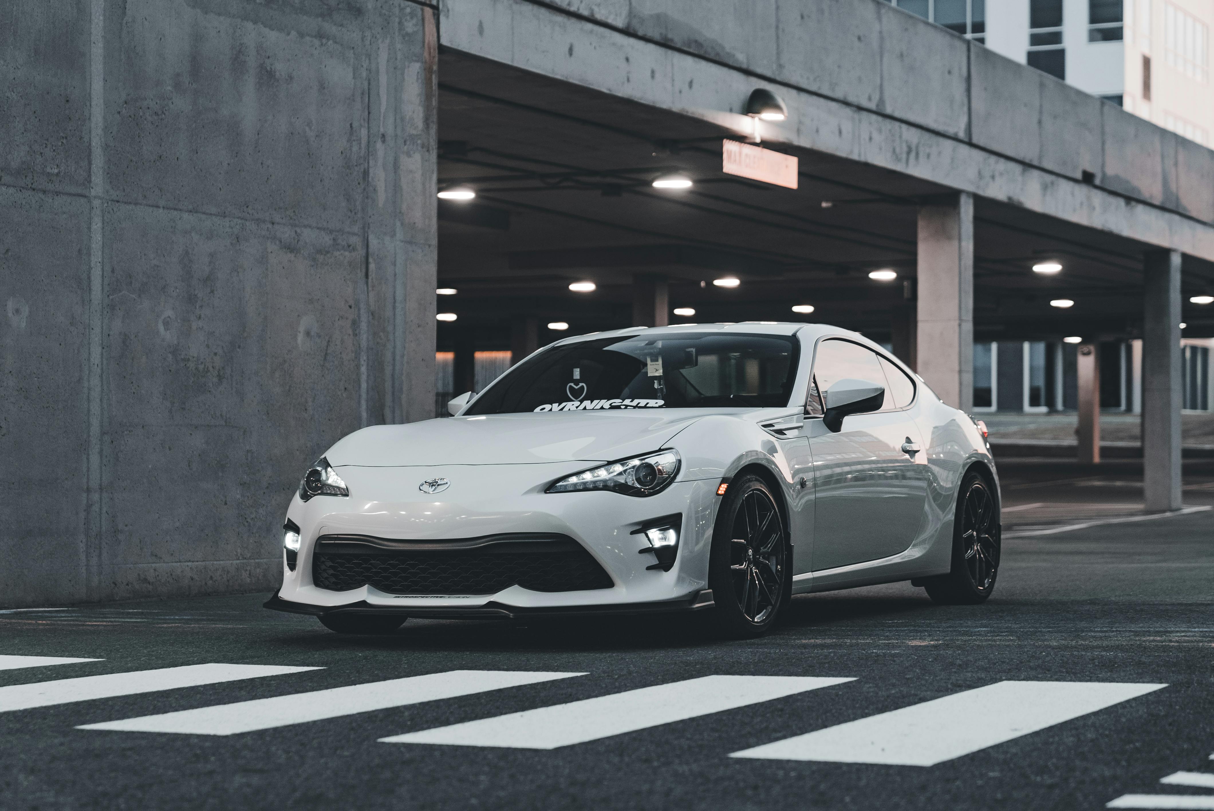 white toyota sports car waiting in front of a zebra crossing