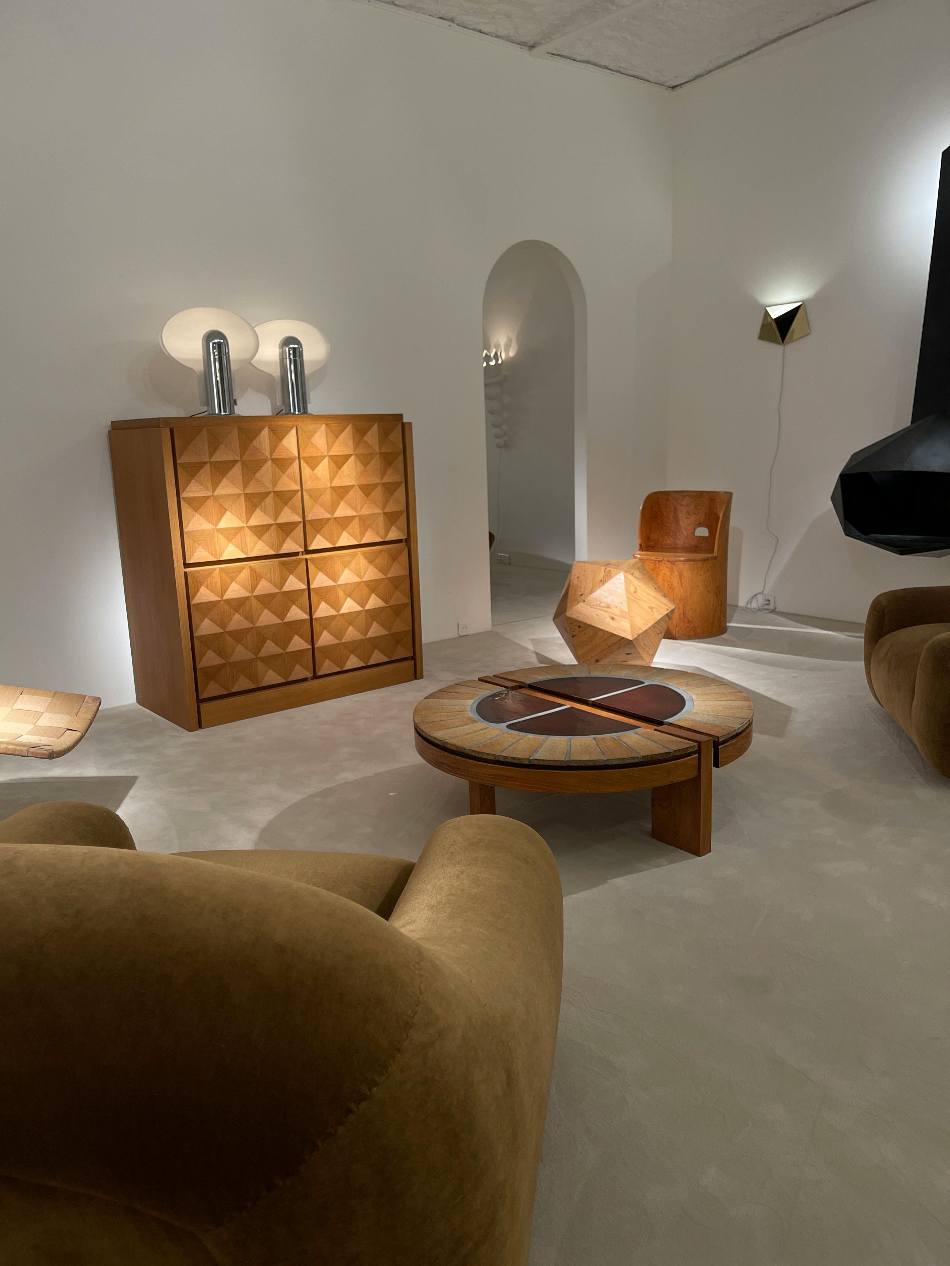 A living room with a coffee table, two chairs and a lamp