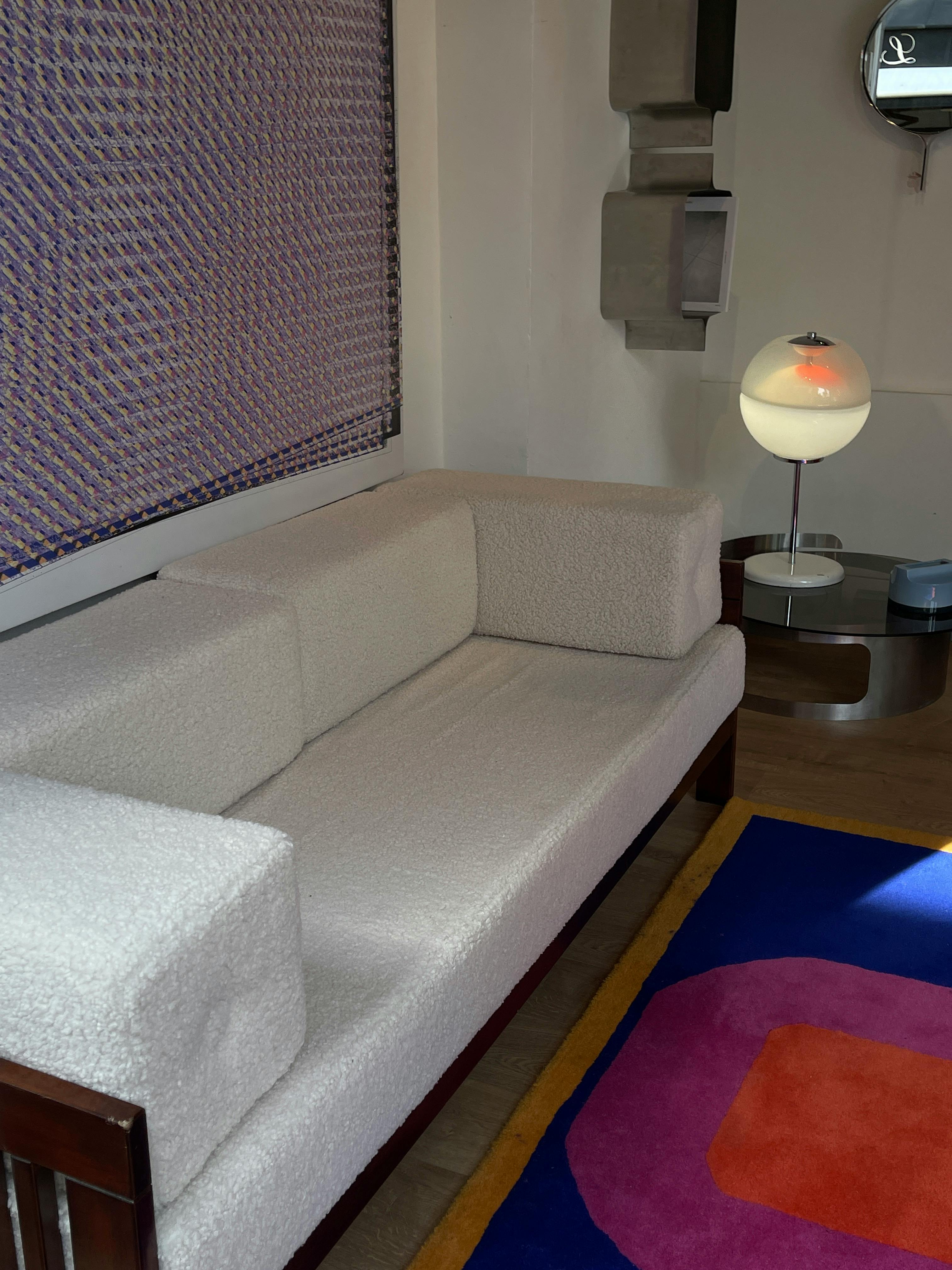 A white couch in a room with a rug and lamp