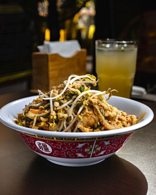 Free A delicious Asian noodle dish topped with bean sprouts served with a refreshing drink on a sunny day. Stock Photo