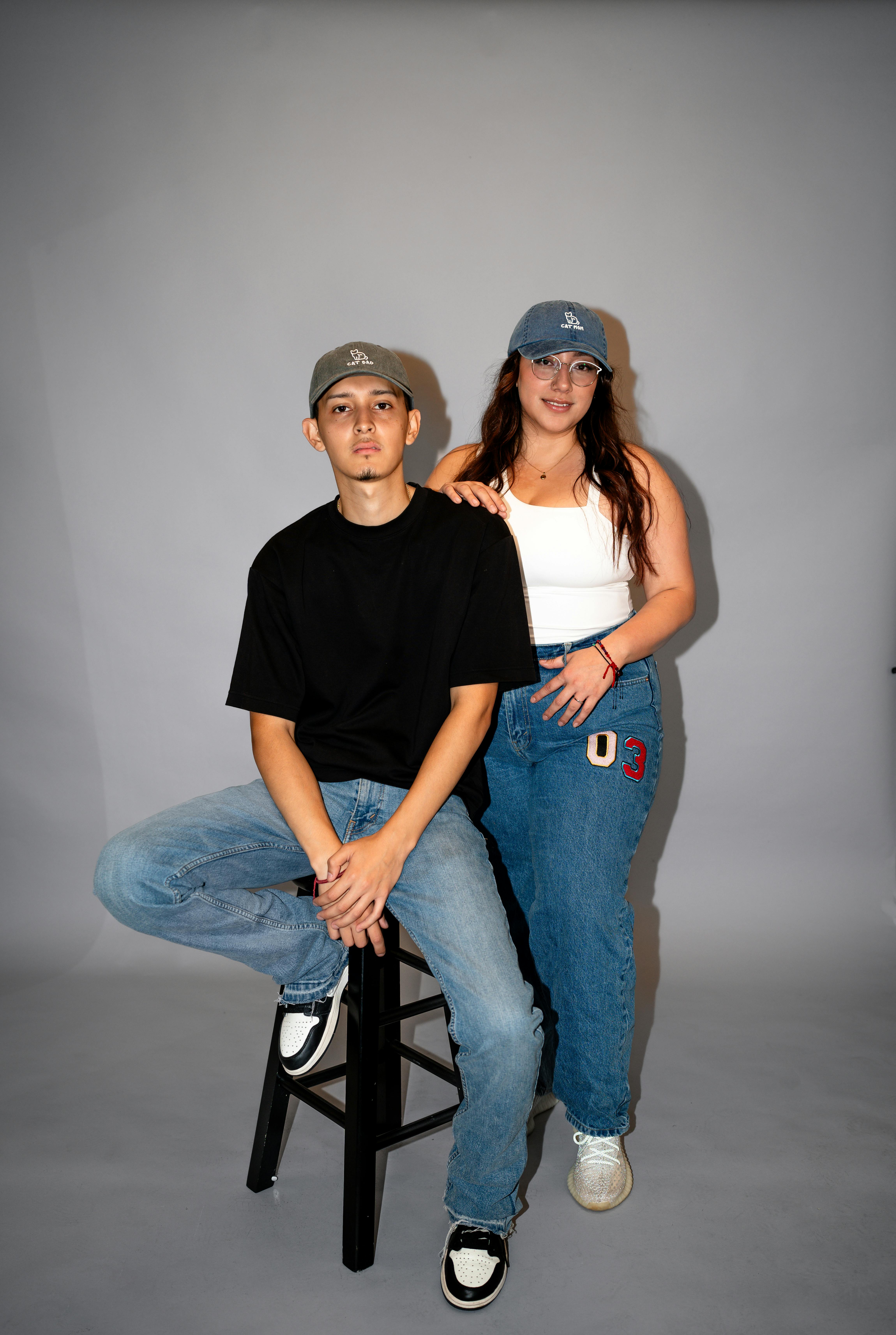 a man and woman sitting on a stool