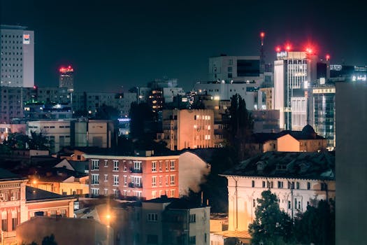 Illuminated cityscape of Bucharest at night featuring vibrant lights and architecture.