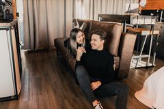 A joyful couple sharing a tender moment on the floor by the sofa in a cozy living room.