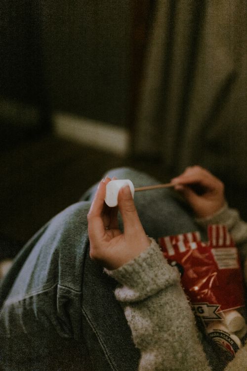 Free A cozy indoor scene featuring popcorn and a marshmallow on a stick, perfect for leisure moments. Stock Photo