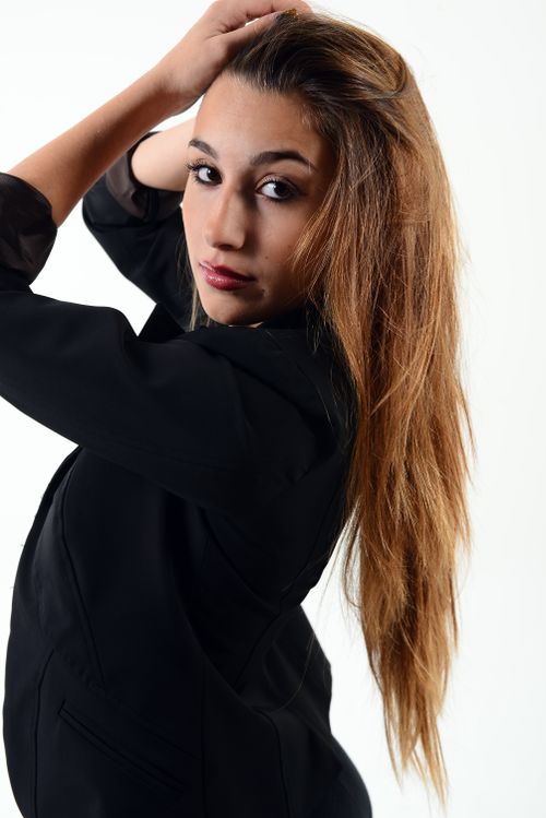 Free Stylish portrait of a young woman with long hair in a black outfit. Stock Photo