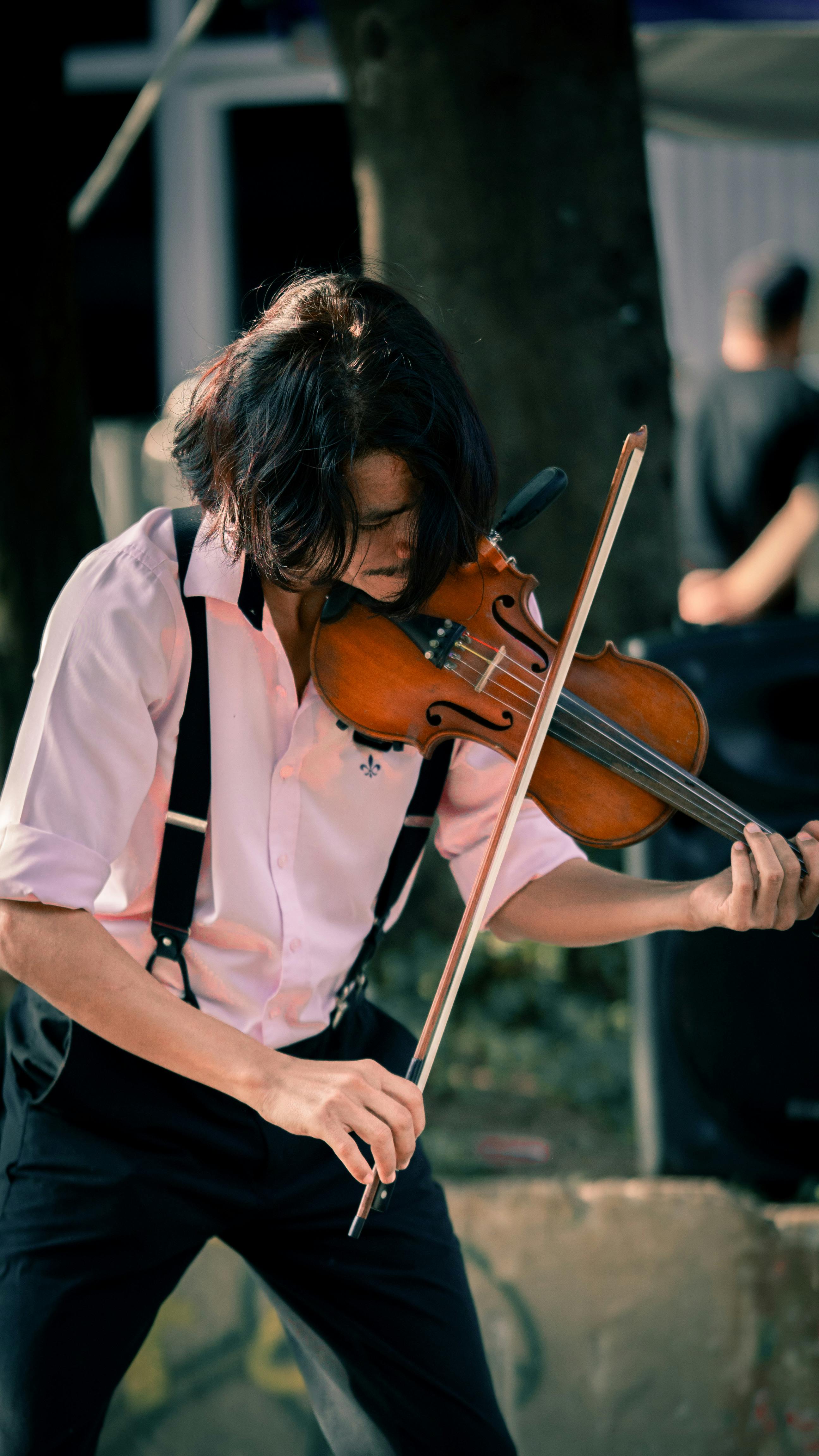 a man playing the violin in a park