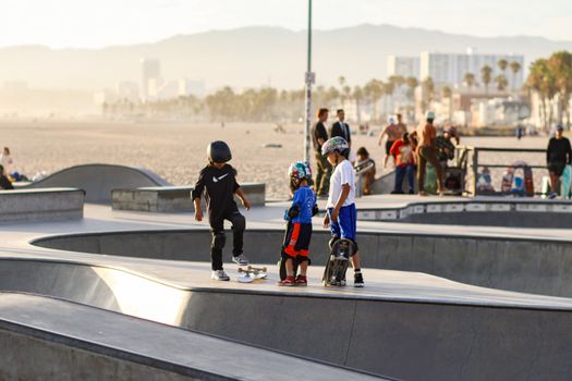 Young skaters at Venice Beach Skatepark on a sunny day, engaging in fun and recreation.