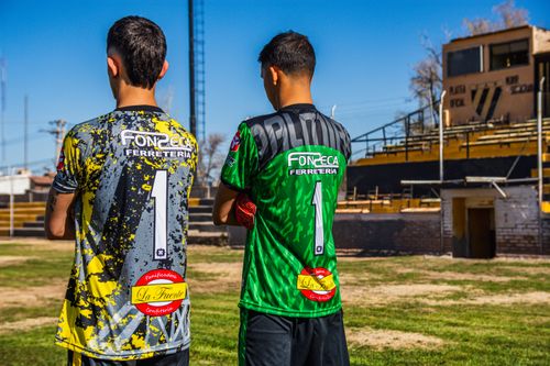 Free Two young soccer players in colorful jerseys, ready for a match on an urban field. Stock Photo