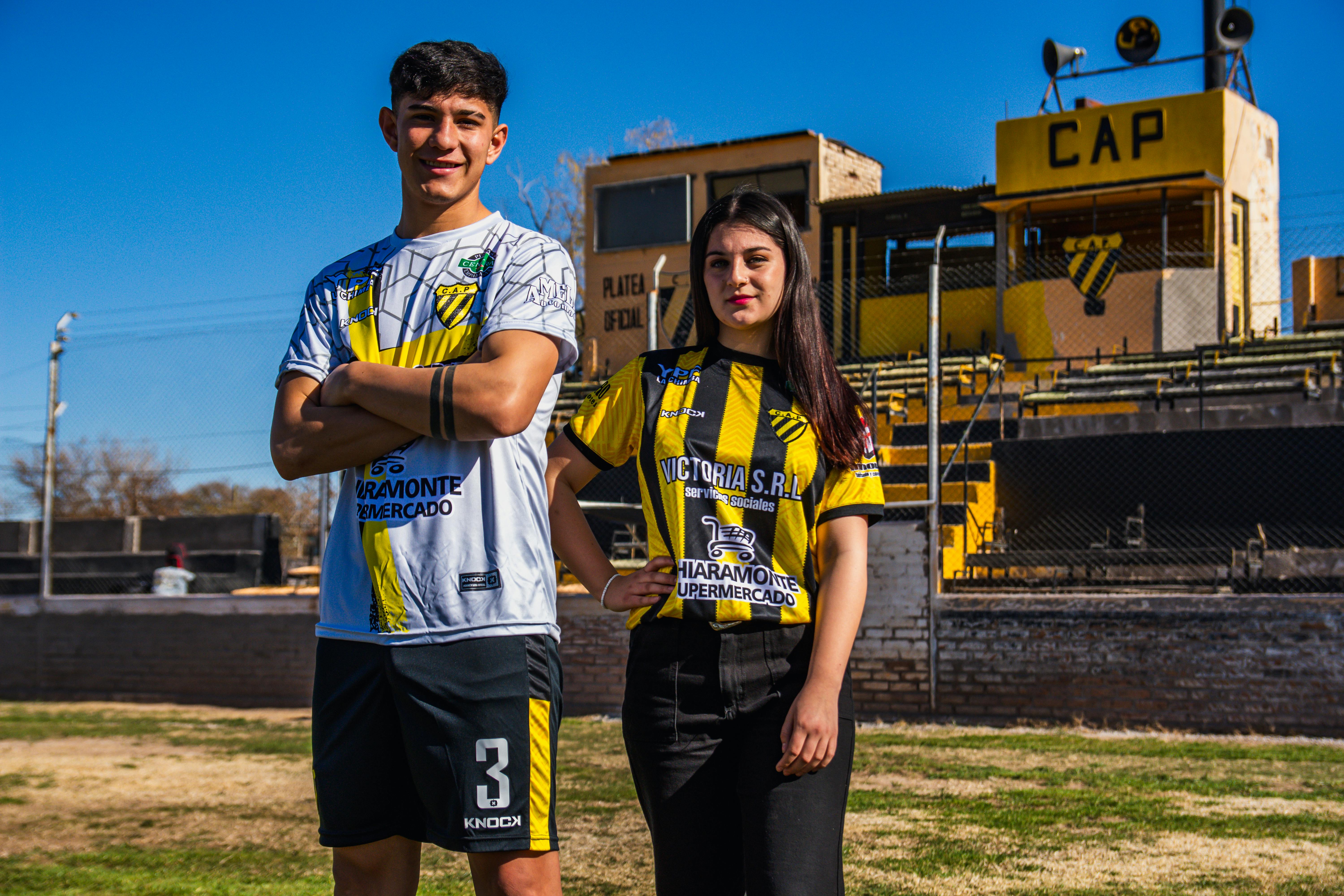 two people standing in front of a soccer field