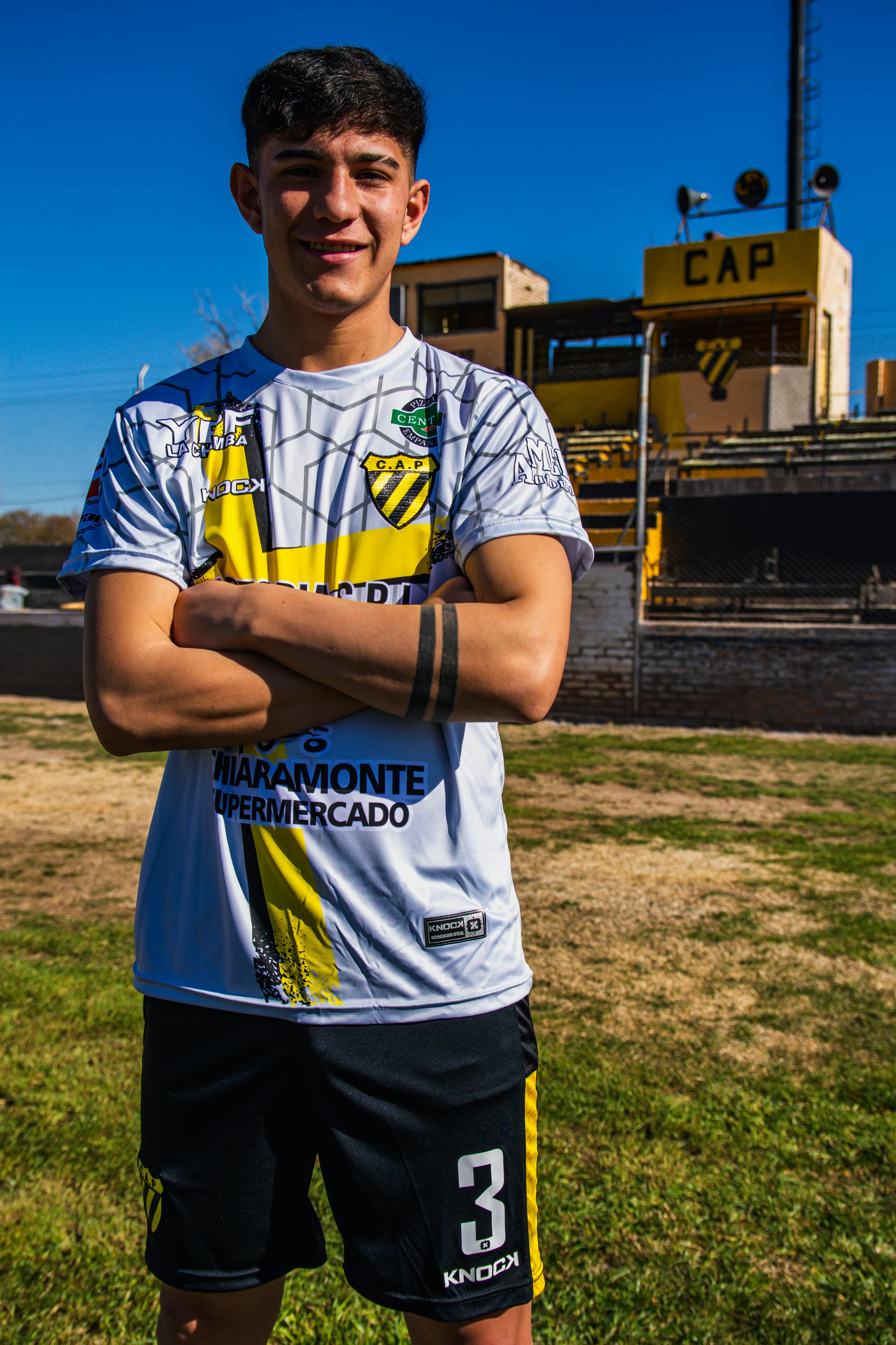 a young man in a soccer uniform posing for a picture