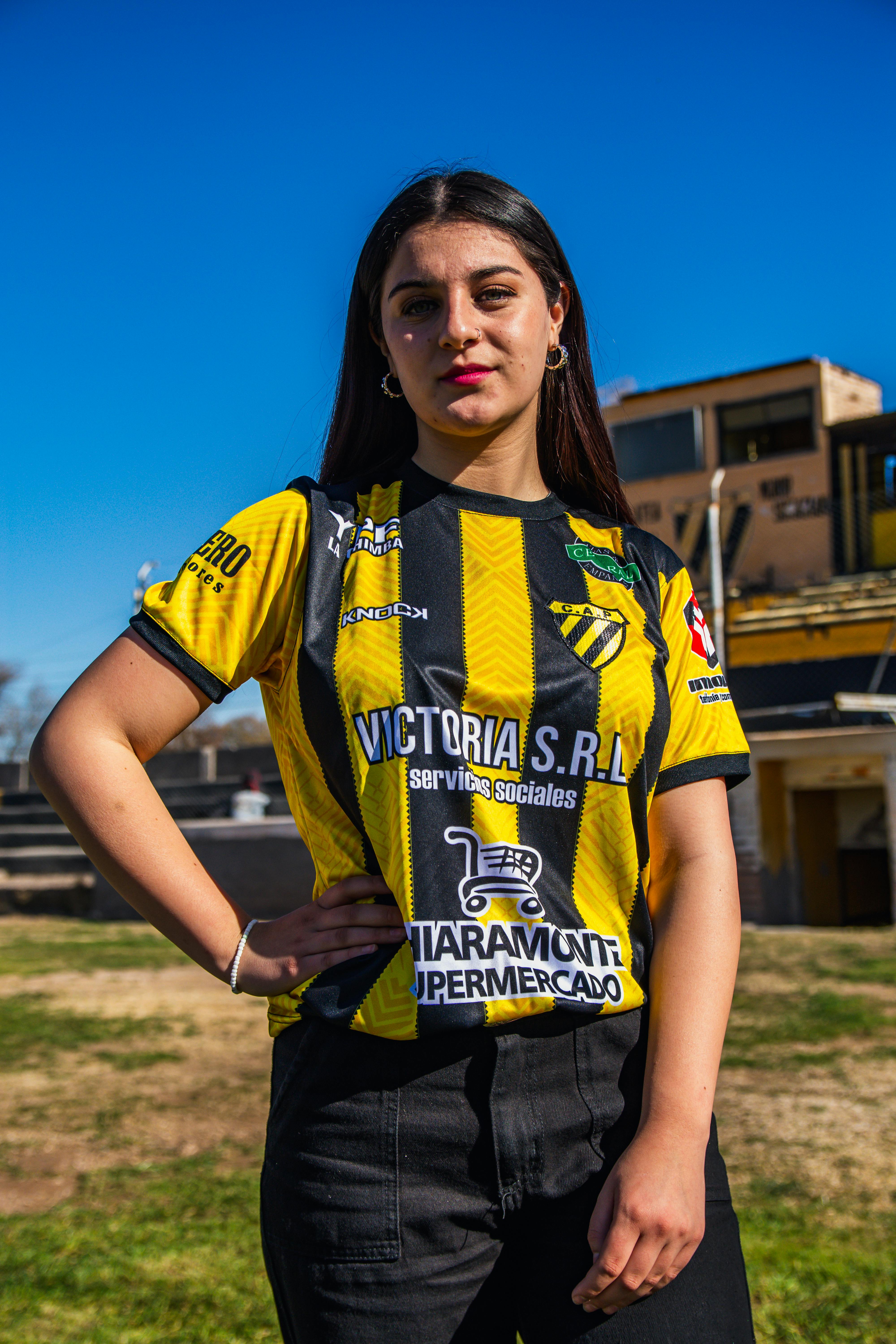 a woman in a yellow and black soccer jersey