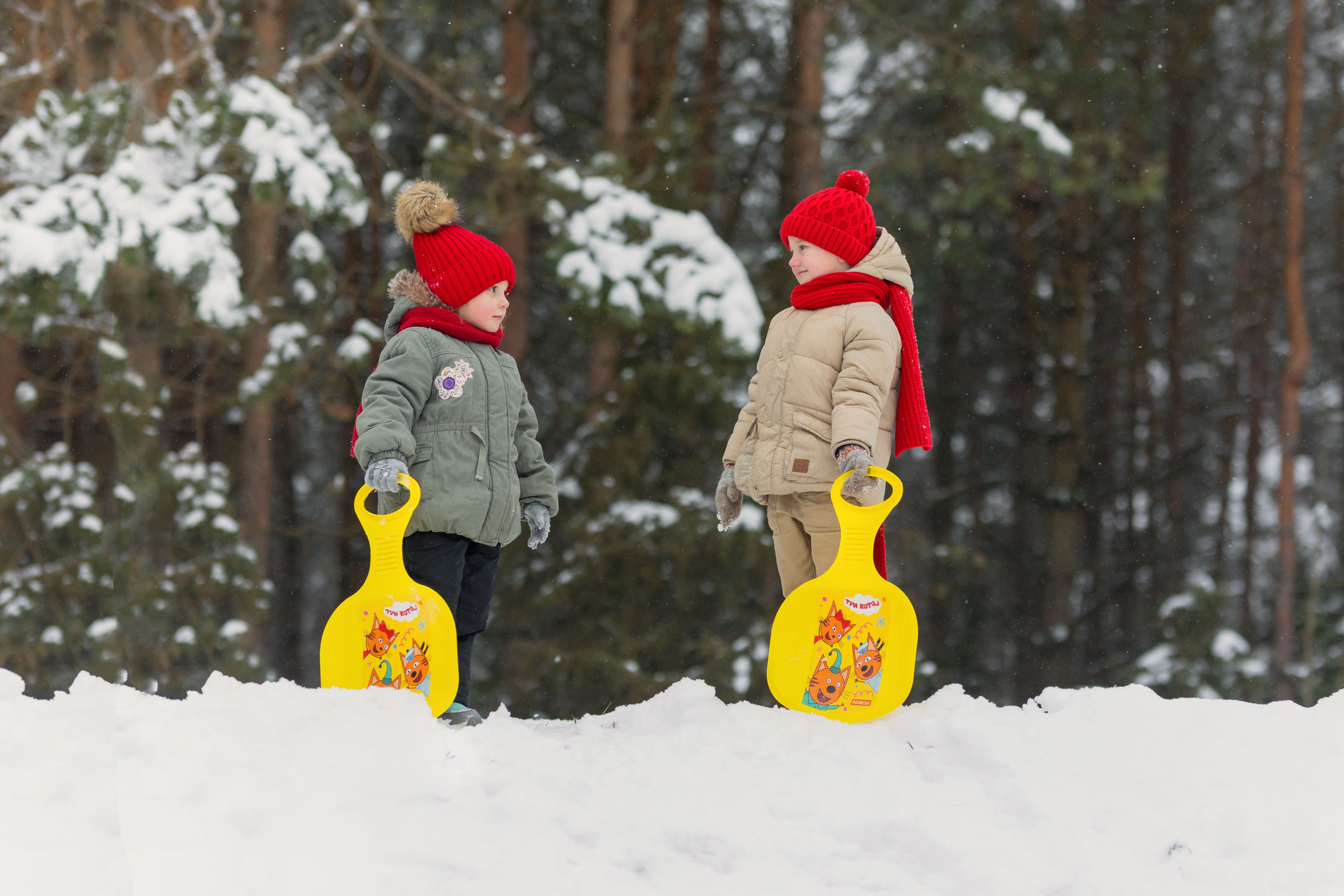 Two children playing in the snow with snow shovels · Free Stock Photo