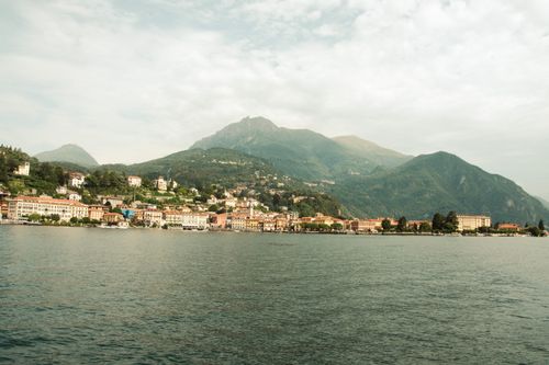 Free A picturesque view of Bellano village by Lake Como in Lombardy, Italy, surrounded by lush hills. Stock Photo