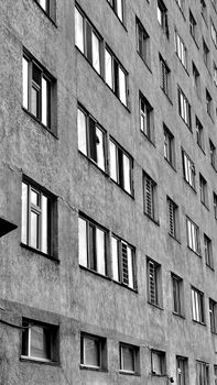 Black and white photo of a geometric urban apartment building facade with windows.