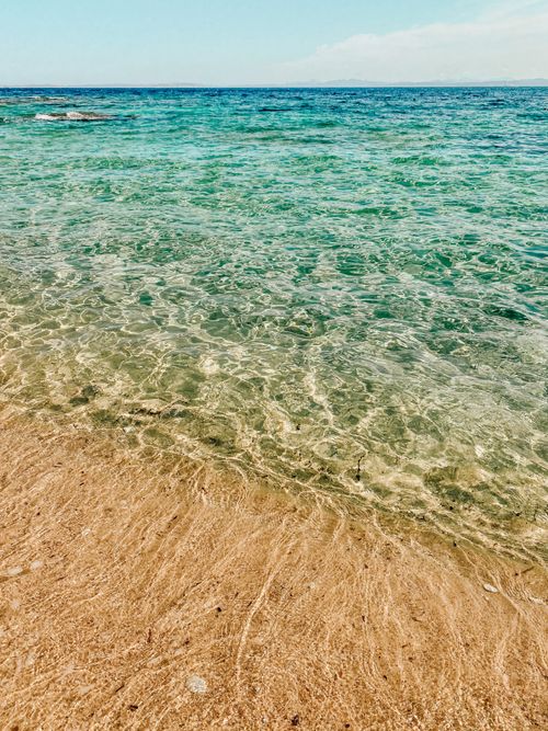 Free Clear turquoise waters of Bonifacio's sandy beach in Corsica under a bright summer sky. Stock Photo