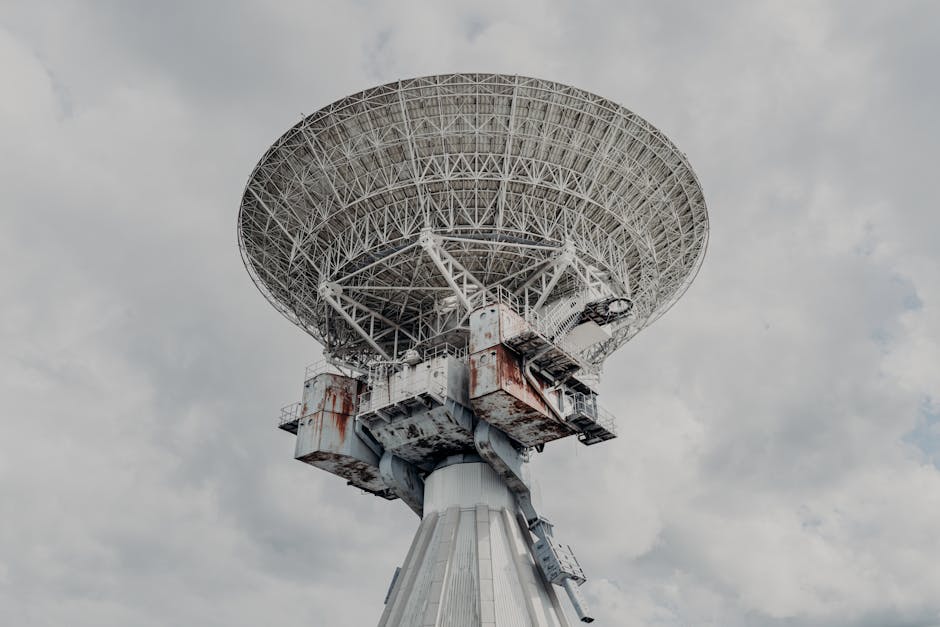 Close-up of a large radio telescope against a cloudy sky.