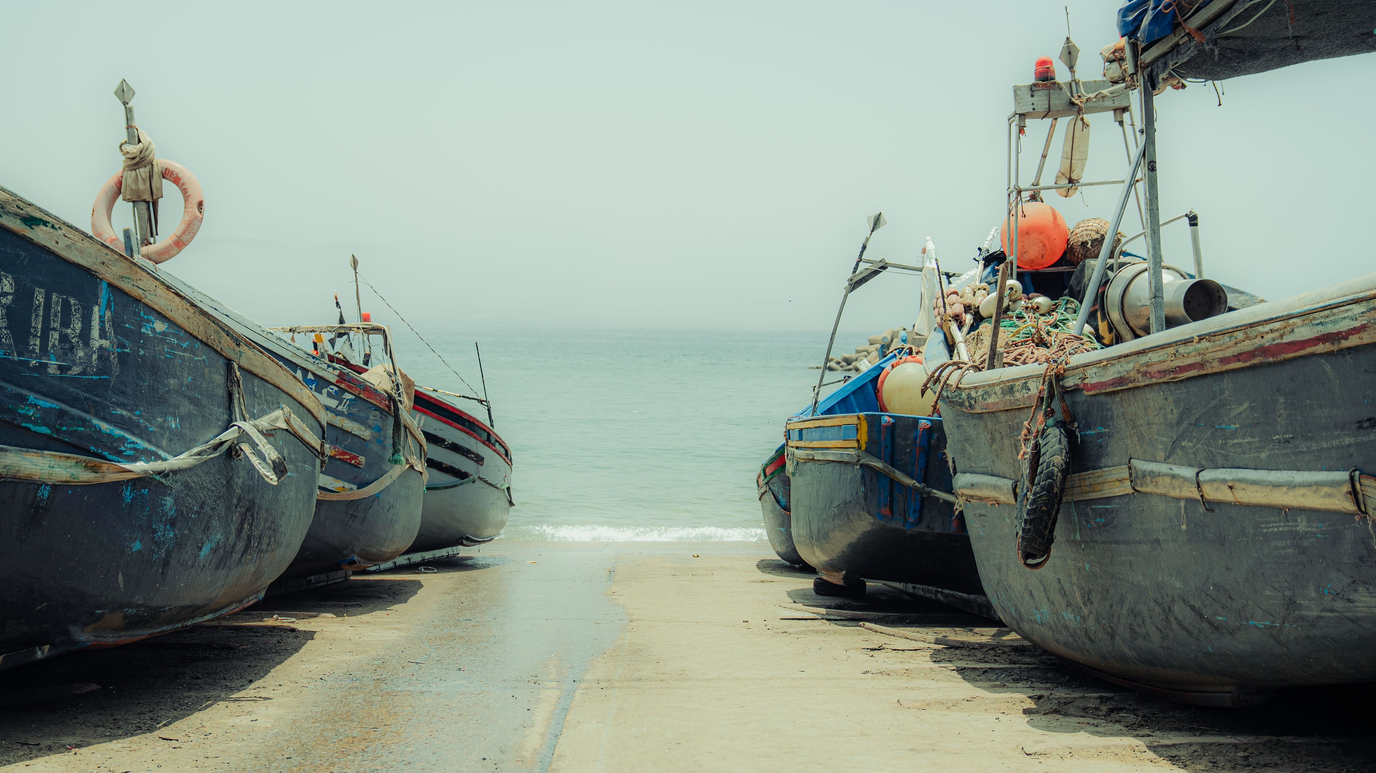 Traditional fishing boats lined up at Imsouane Beach in Morocco, ready for a day at sea.