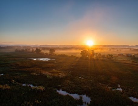 A beautiful sunrise with mist covering the Kellogg countryside, captured with glowing reflections.