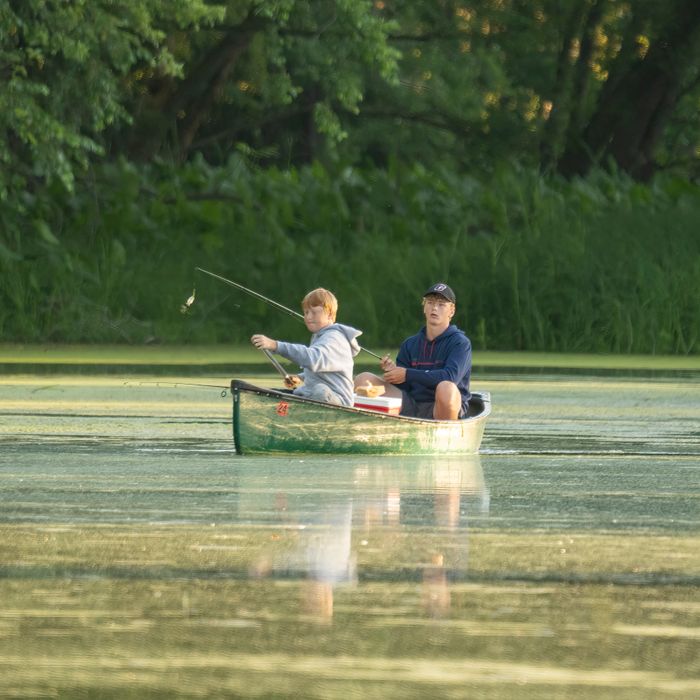 Two paddlers sharing a flask on a still lake — photo by Tom Fisk on Pexels