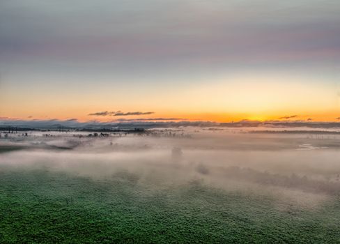 A breathtaking sunrise over misty landscapes in Kellogg, MN, creating a serene atmosphere.