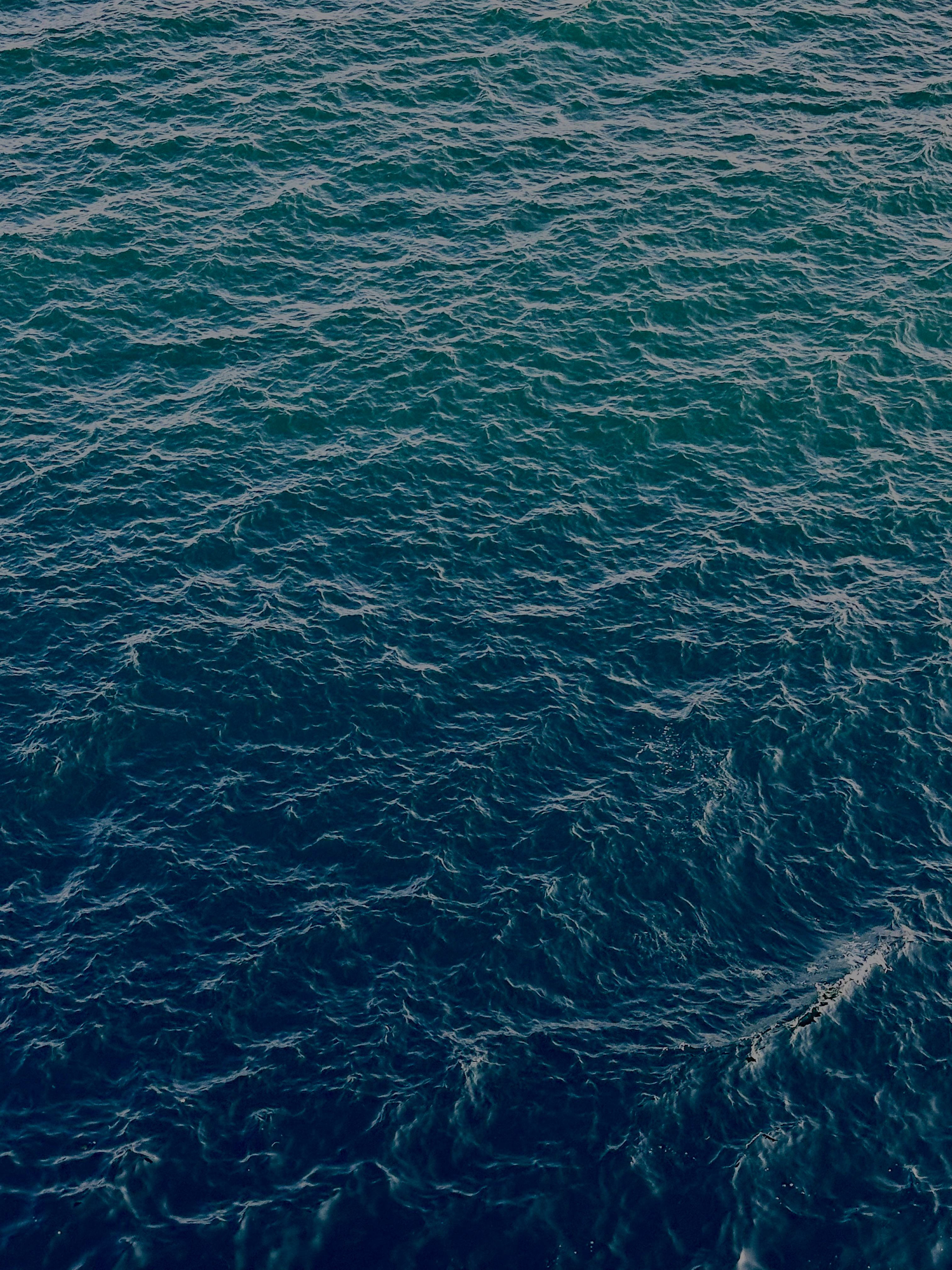 Dynamic image of turquoise sea waves with a rippling pattern.