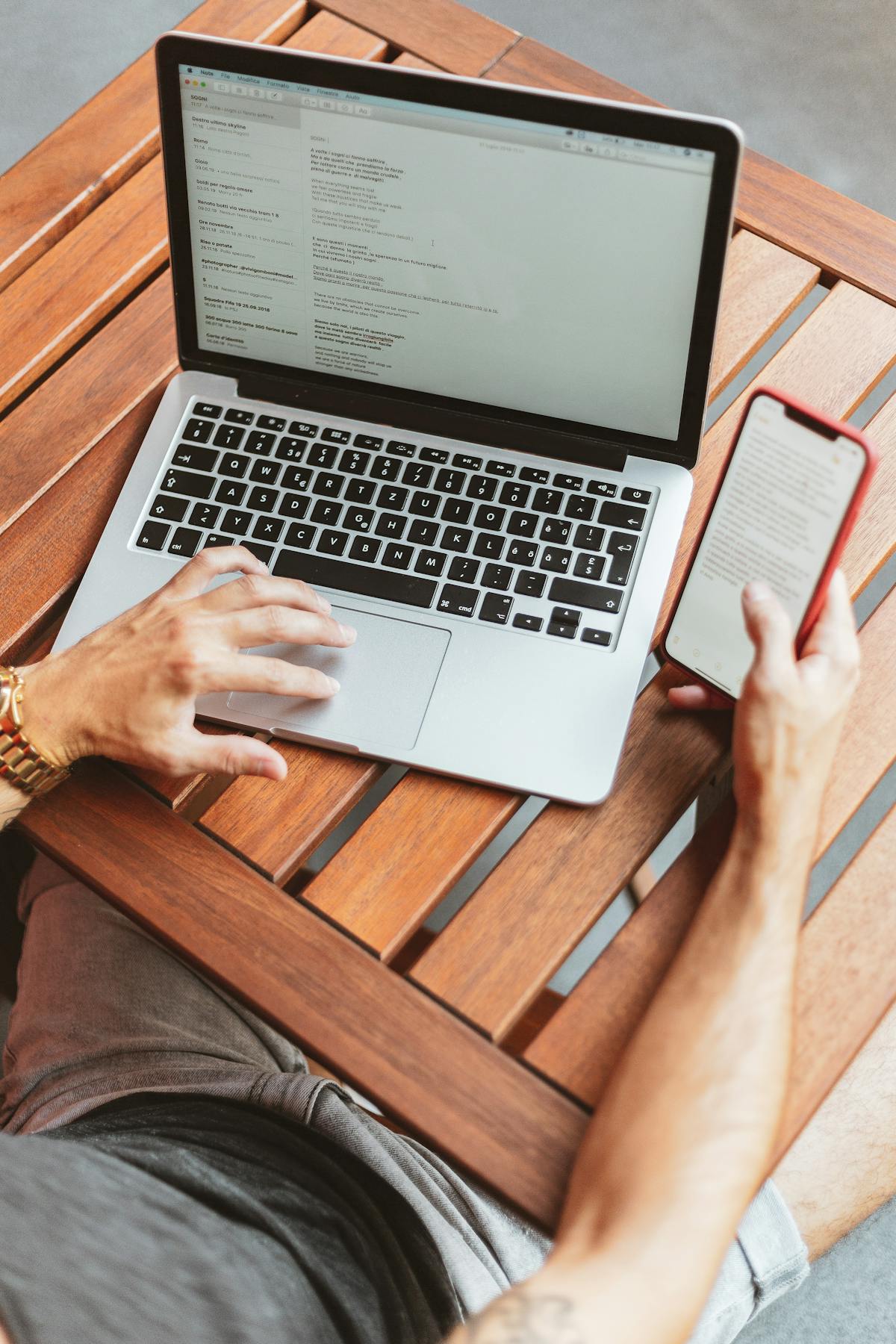 Creator editing a vertical short video on a laptop and phone simultaneously
