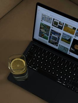 A laptop with a glass of lemon water on the keyboard, showcasing a casual workspace setting.