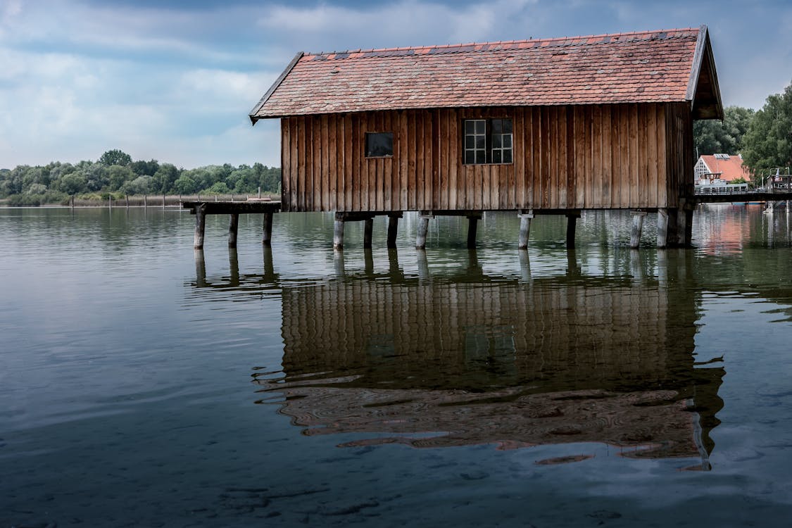 бесплатная Коричневый деревянный дом на реке Стоковое фото