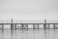 黄昏时分，黑白码头宁静的场景映照着平静的海面，营造出祥和的氛围