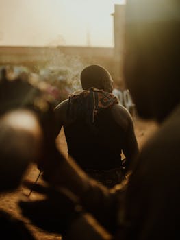 Artistic capture of people in a vibrant Nigerian street scene during sunset.