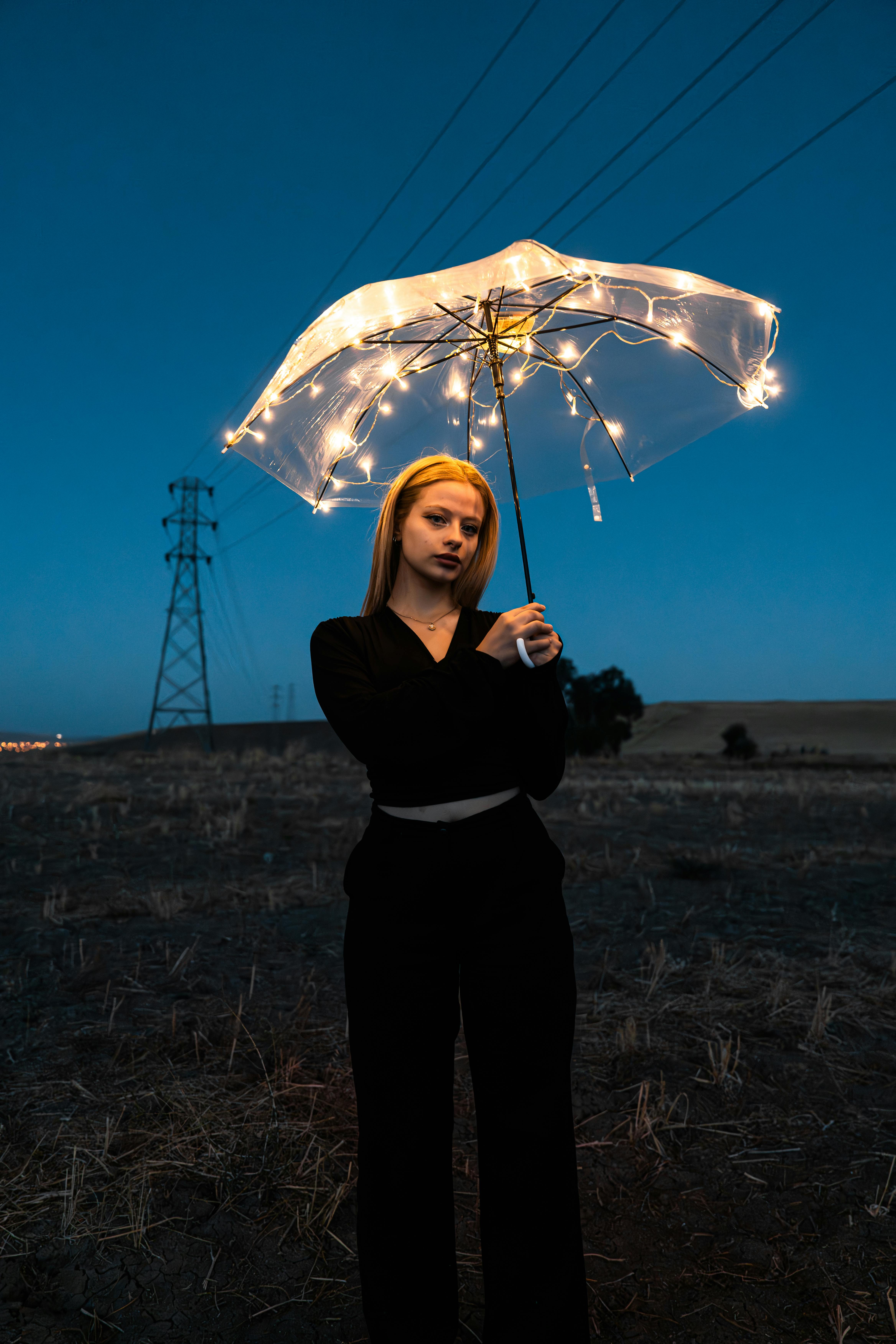 a woman holding an umbrella with lights on it