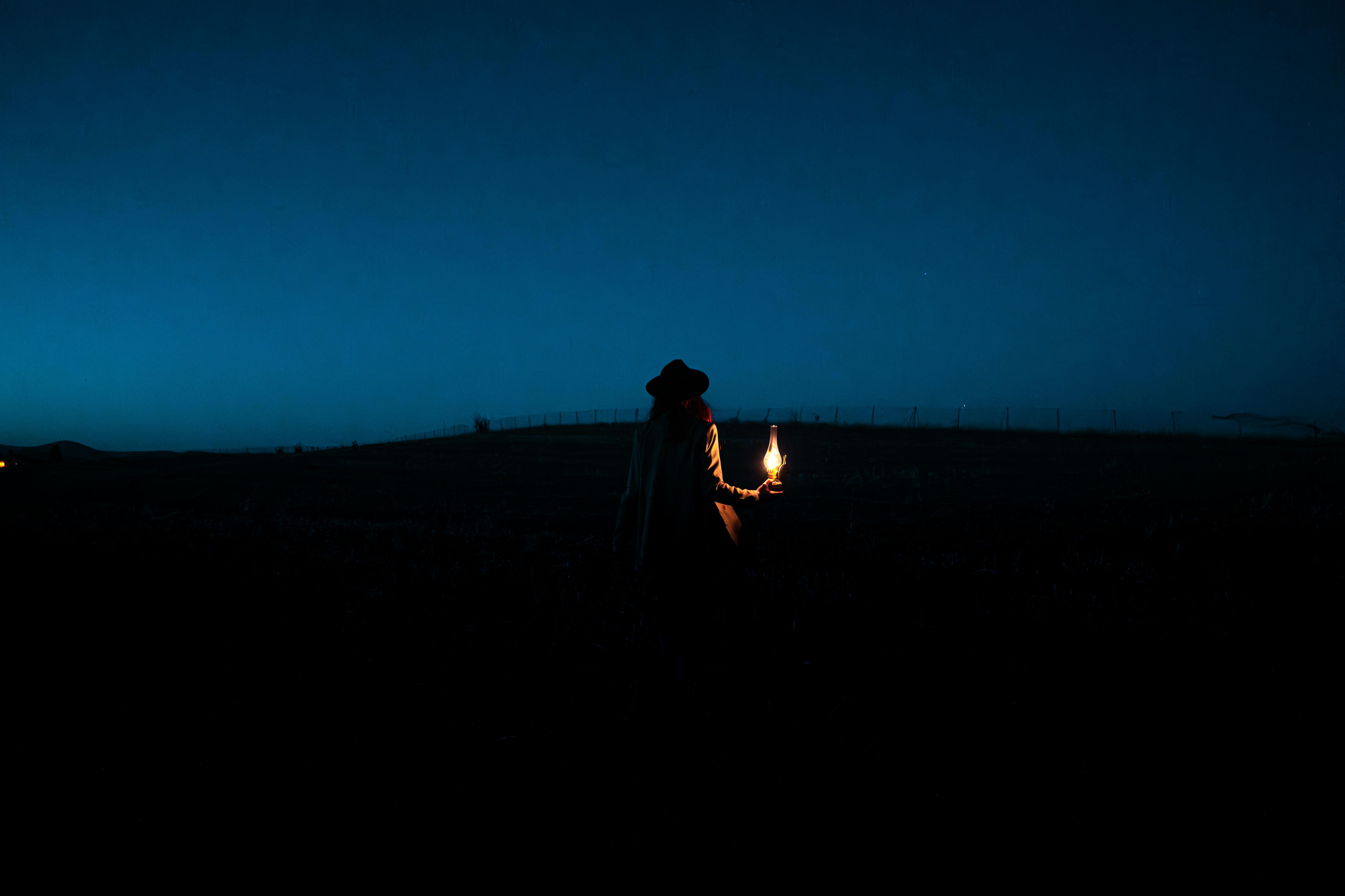 a person holding a candle in the dark