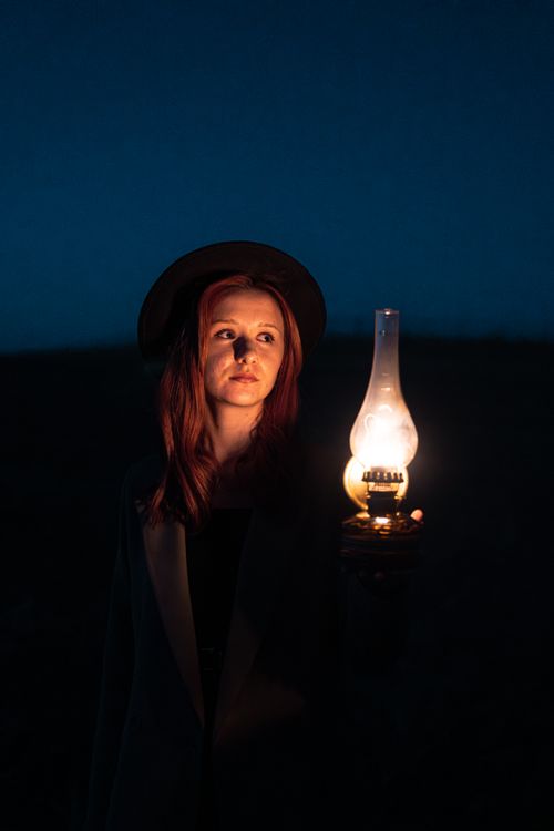 Free Portrait of a woman holding an oil lantern in a dark outdoor setting in Ankara, Turkey. Stock Photo