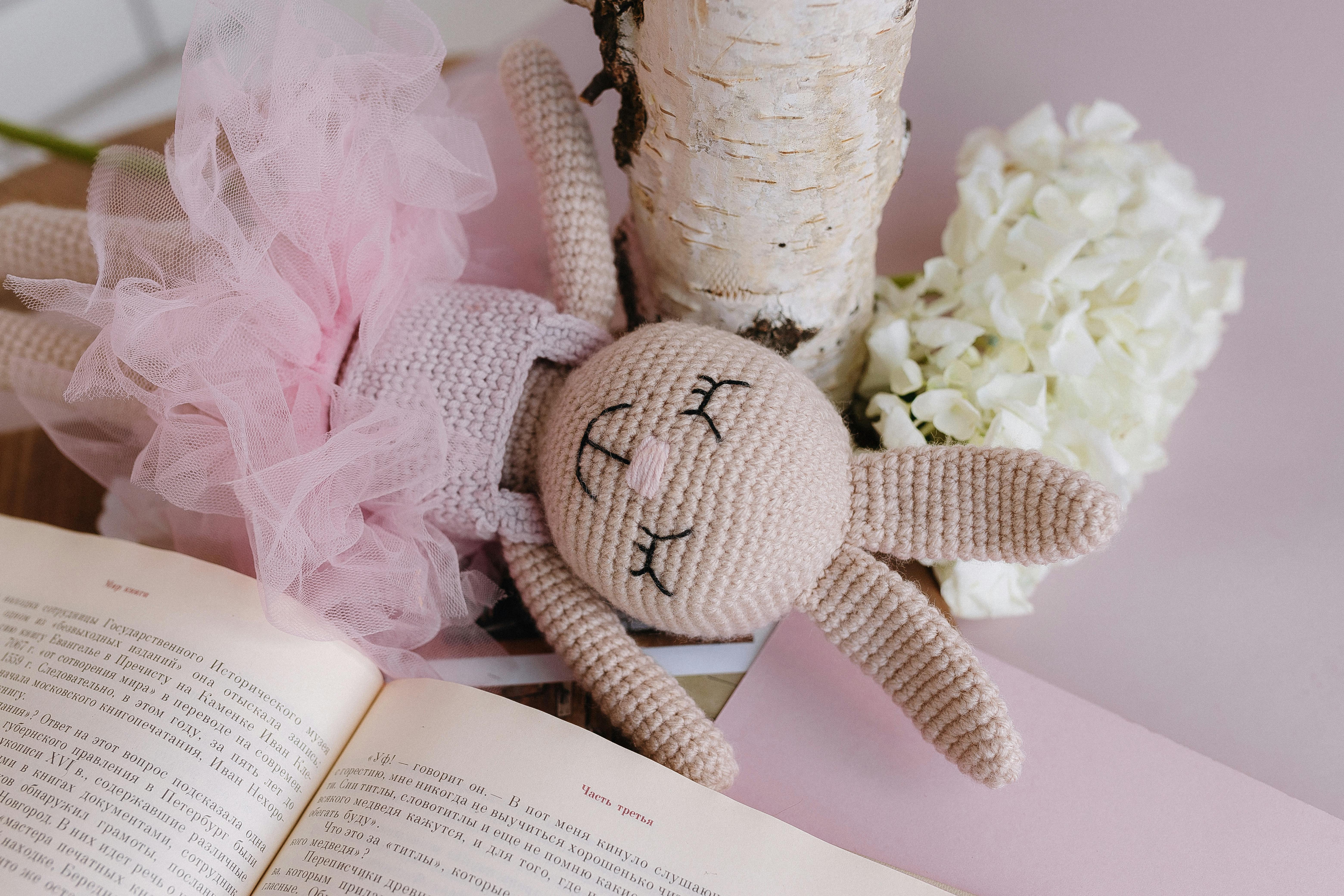 a stuffed rabbit with pink tutu and pink dress on top of a book