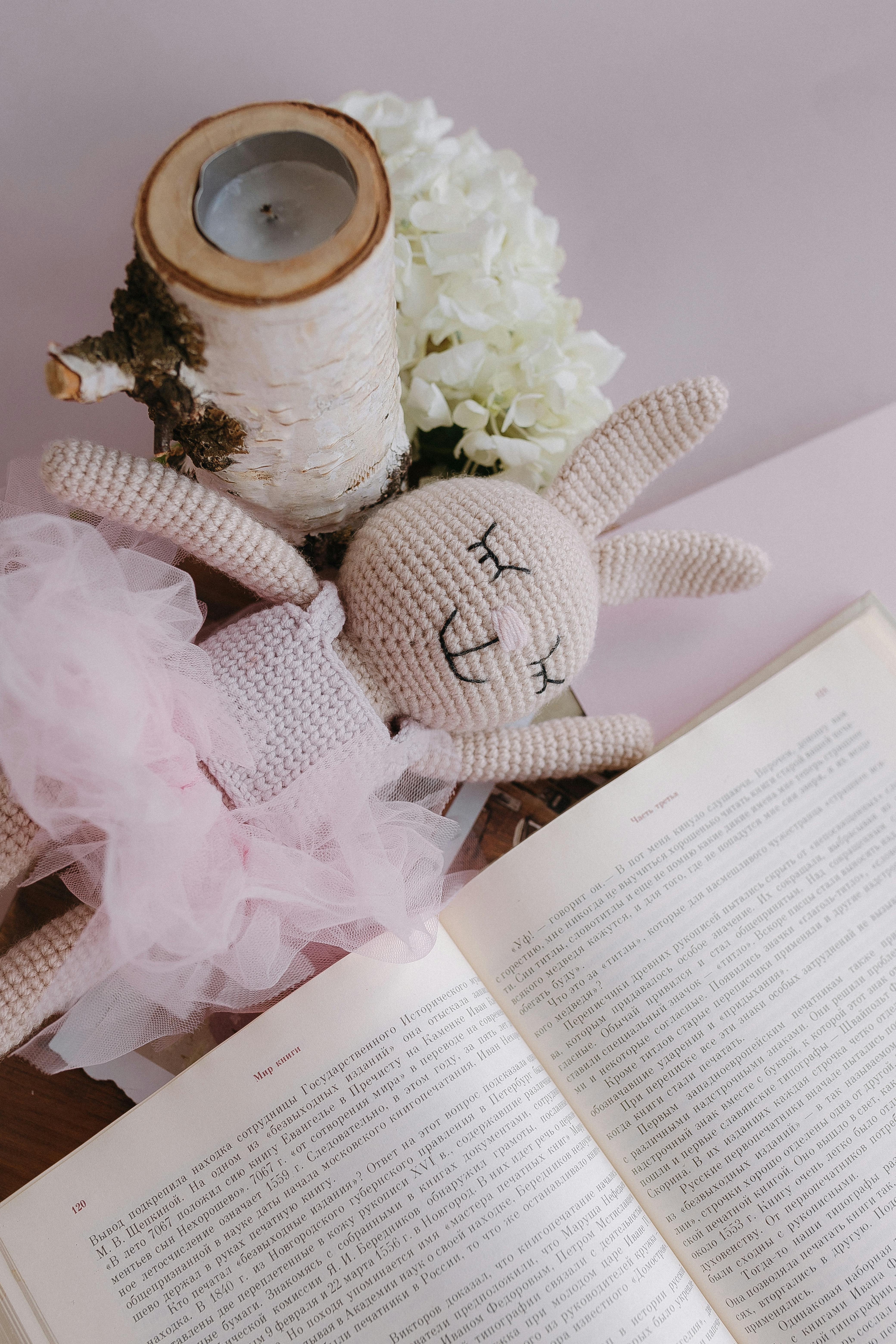 a stuffed rabbit sitting on top of an open book