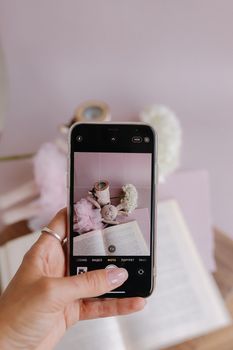 A smartphone capturing a cozy scene with books and soft decor, perfect for lifestyle content.