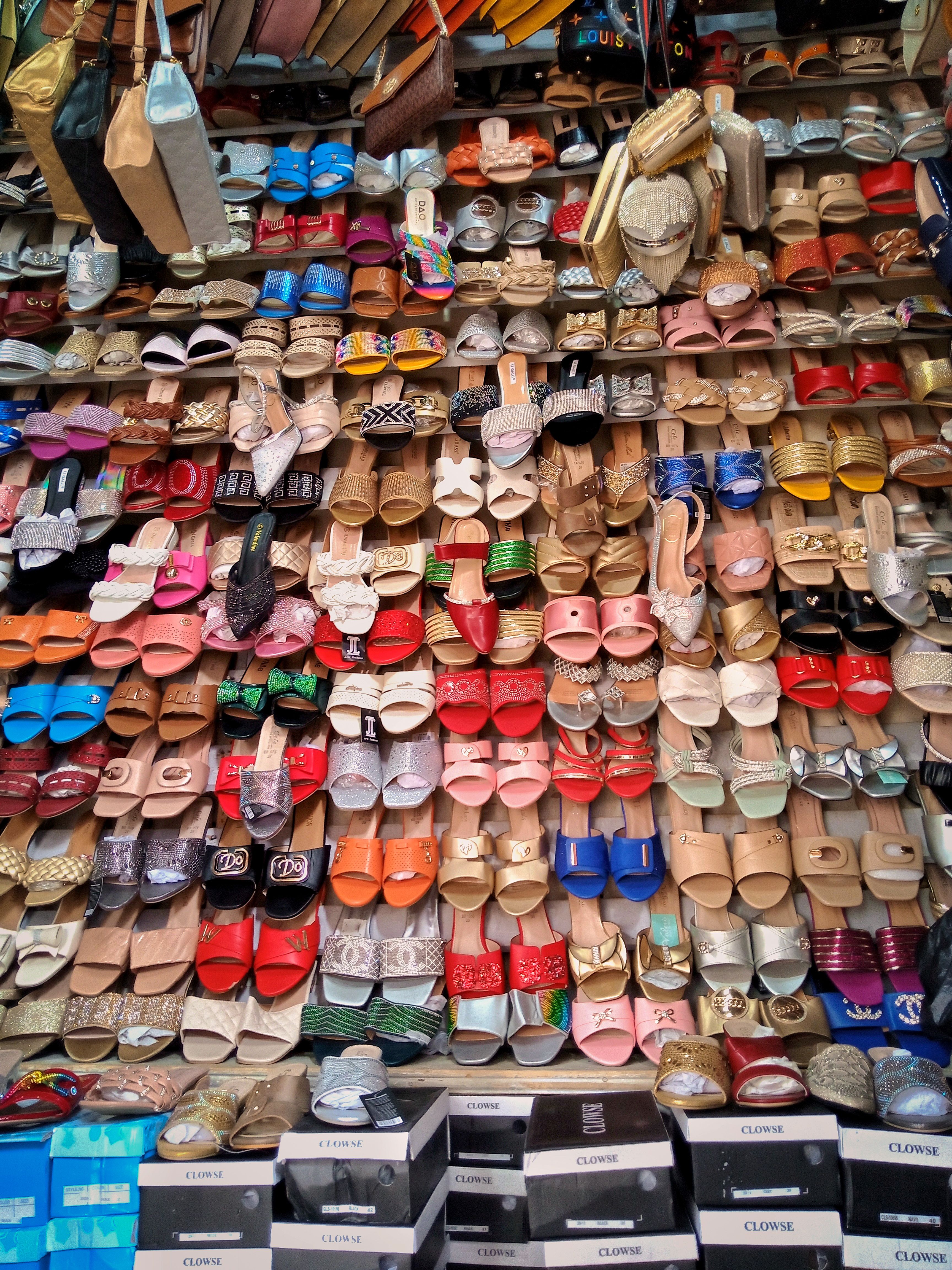 Vibrant display of colorful shoes in a traditional market setting.