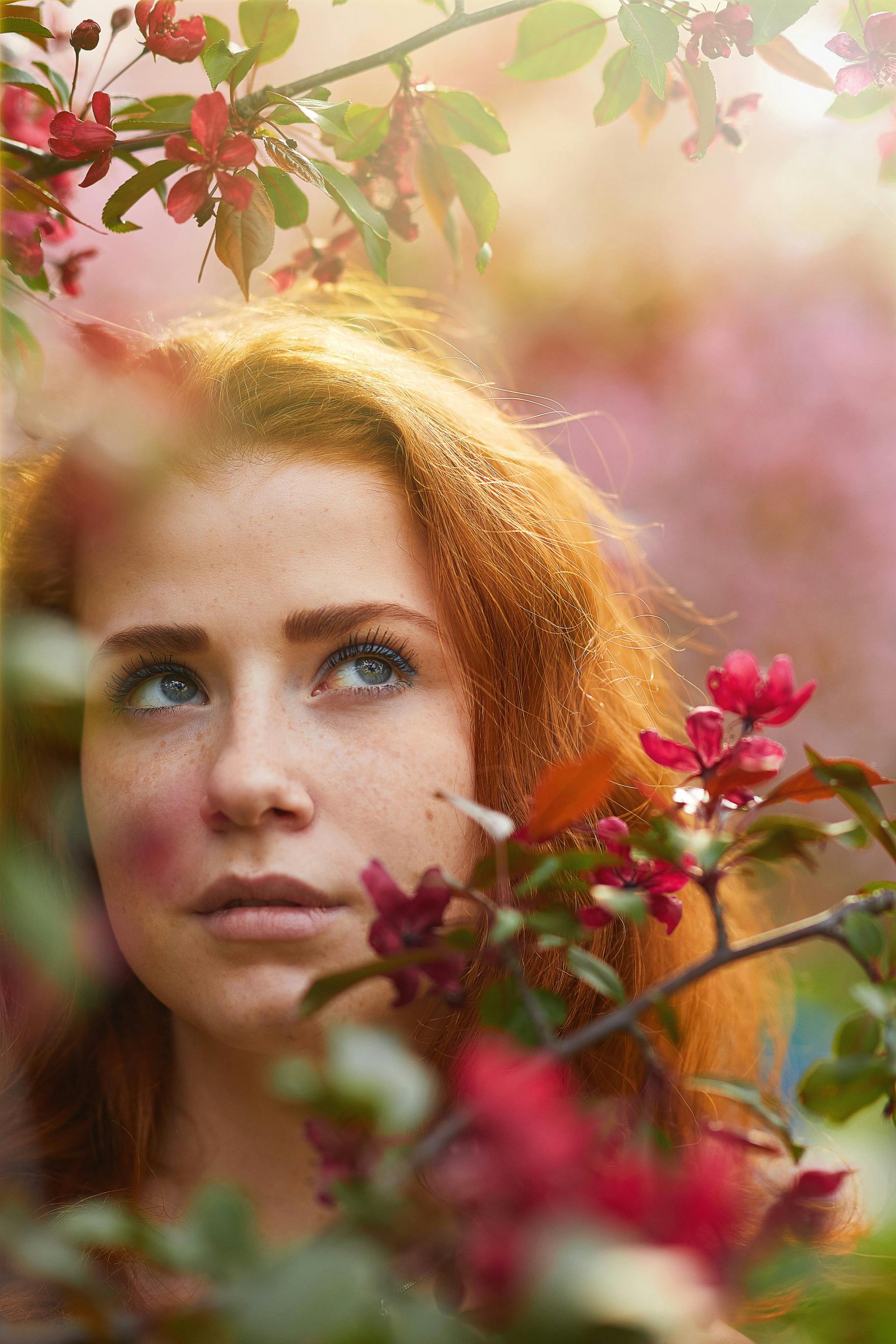 一幅红发女人的惊人肖像被盛开的鲜艳花朵所环绕