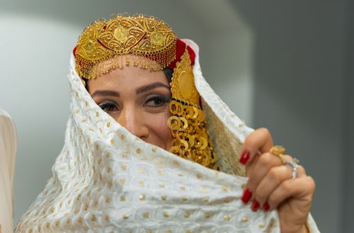 Free A beautiful bride adorned in a traditional gold headpiece with intricate jewelry, creating a sense of cultural elegance. Stock Photo