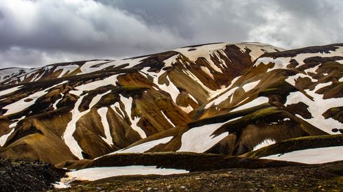 Free Explore the rugged beauty of Iceland's Landmannalaugar with snow-capped mountains and dramatic skies. Stock Photo