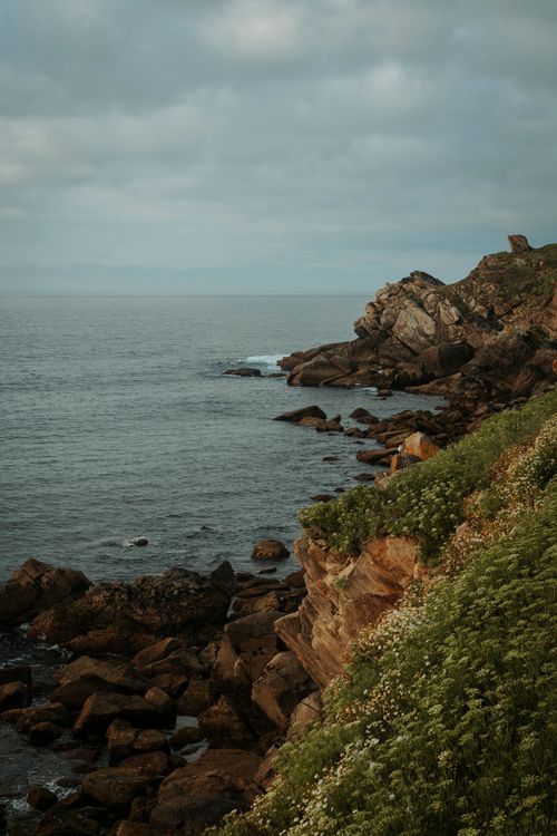 Free Dramatic cliffs and sea in Malpica, Spain, with lush greenery and rocks. Stock Photo