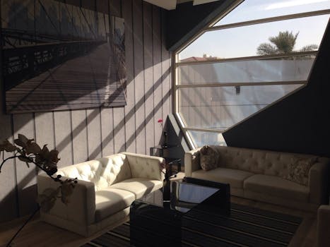 明亮的当代客厅配有大窗户、沙发和艺术品