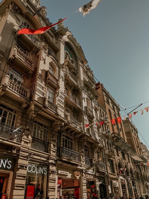 Free Historic urban buildings adorned with flags under a sunny sky, capturing architectural beauty. Stock Photo