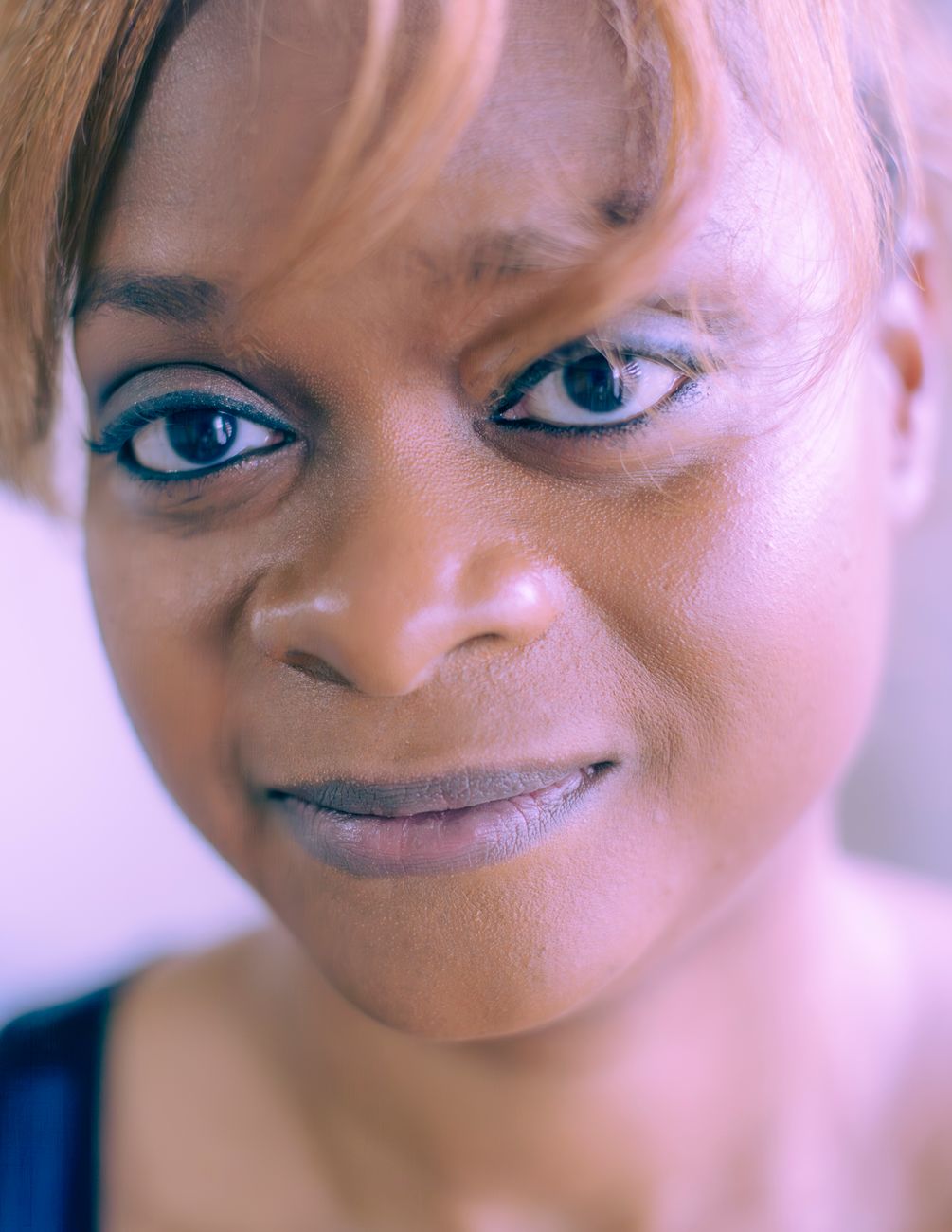 Close-up portrait of a woman with natural expression, highlighting her eyes and smile.