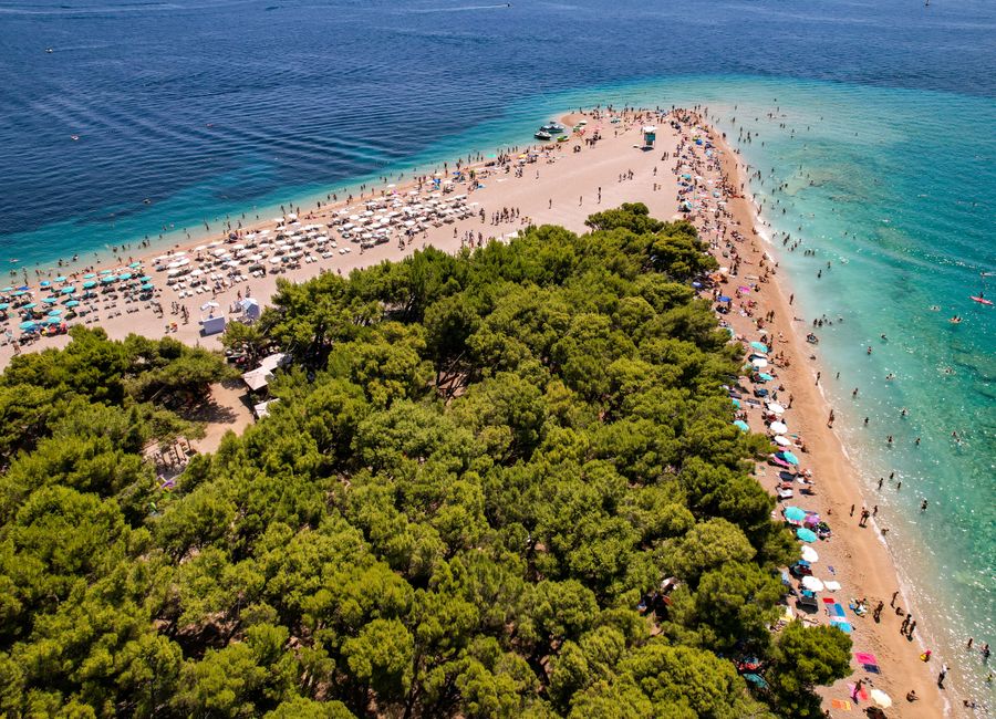 Stunning aerial view of the famous Zlatni Rat Beach with turquoise waters, ideal for summer vacations.