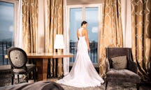 新娘优雅地站在装饰现代、氛围豪华的时尚酒店客房中